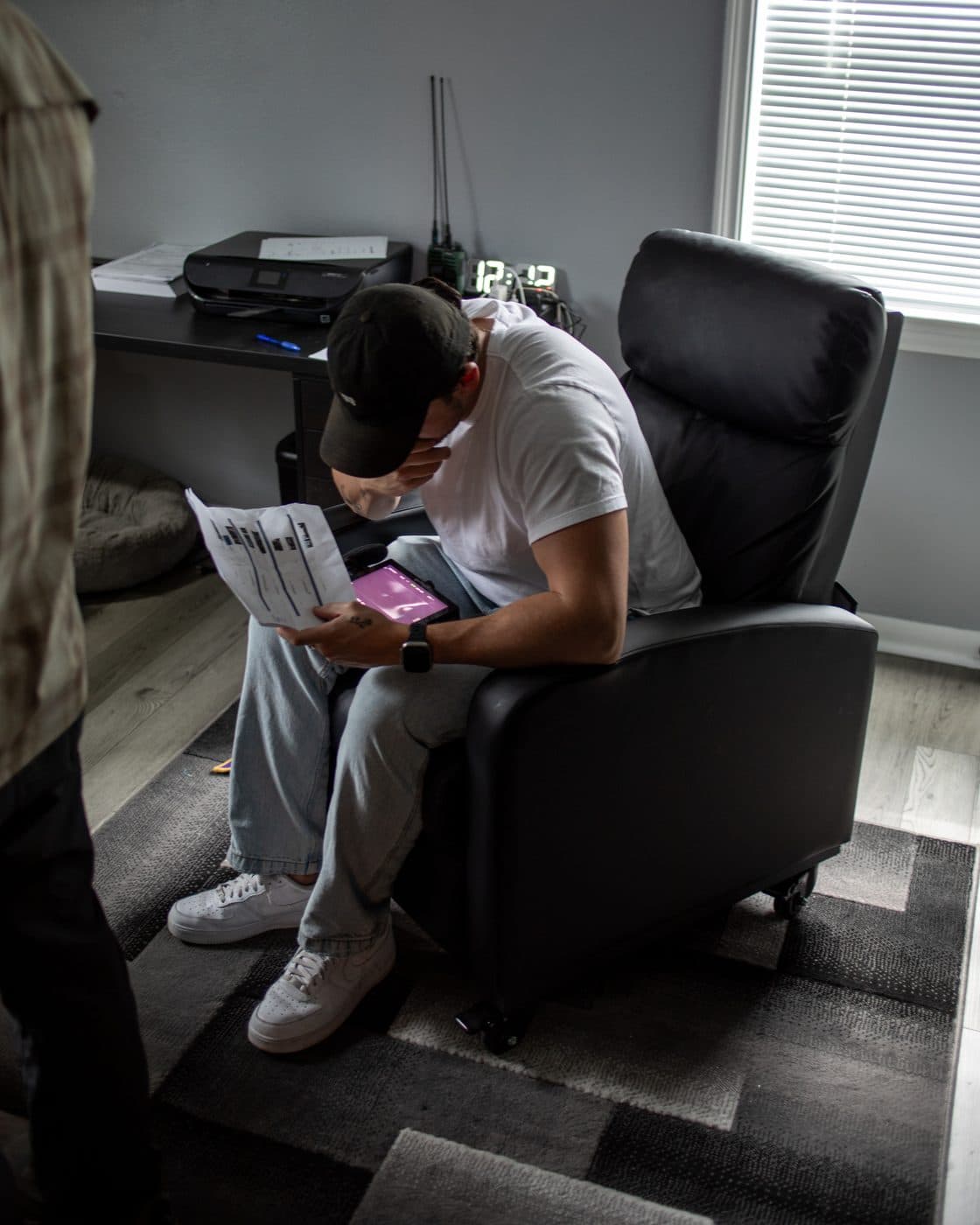 A man reading in an armchair, head bowed.