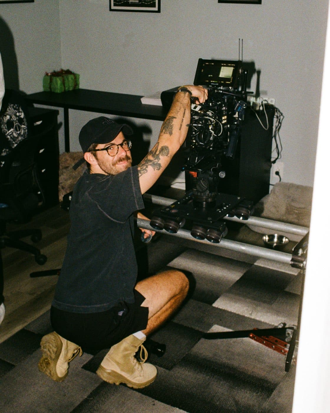 A camera operator kneeling with the rig.