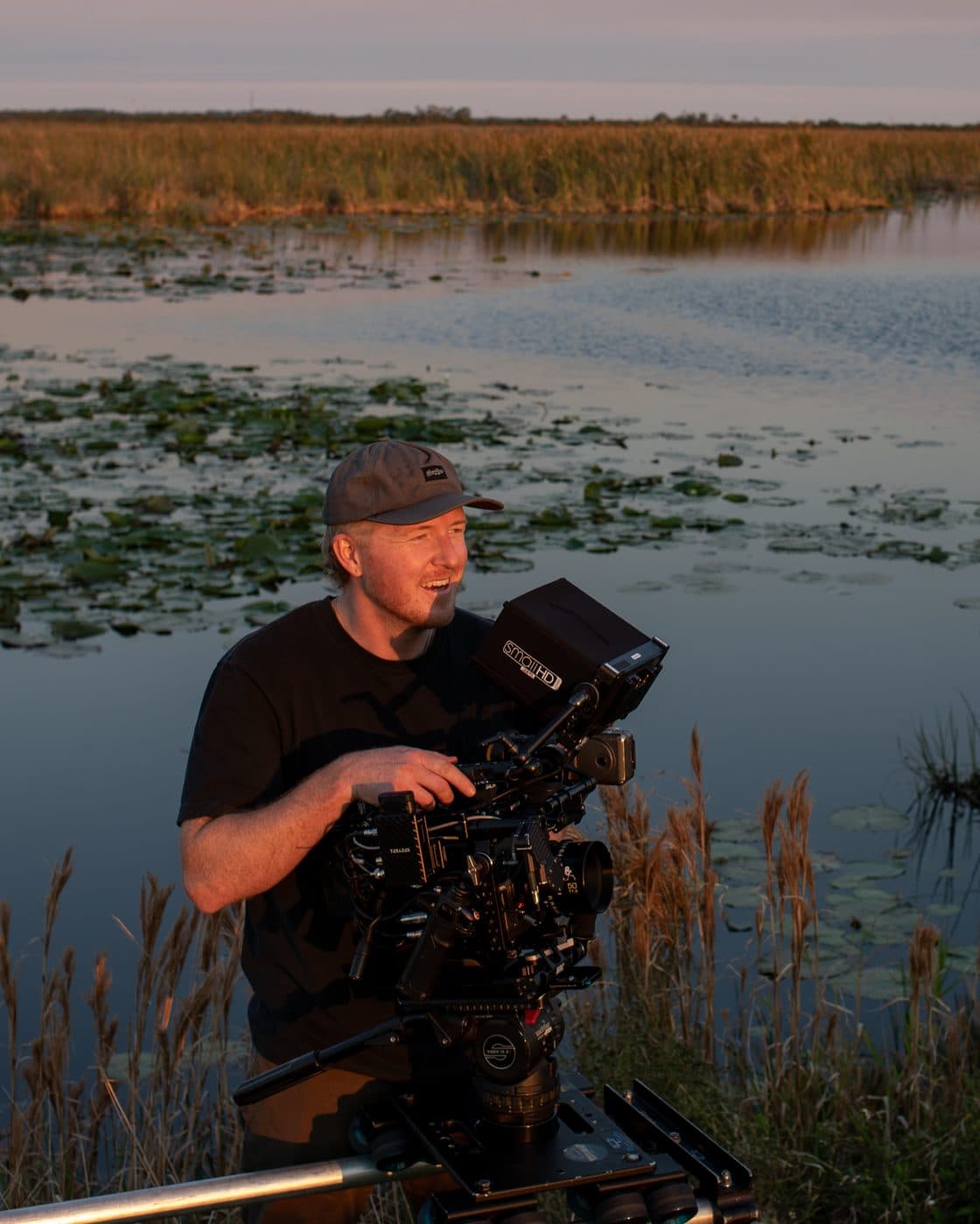 A camera operator in the reeds at golden hour.