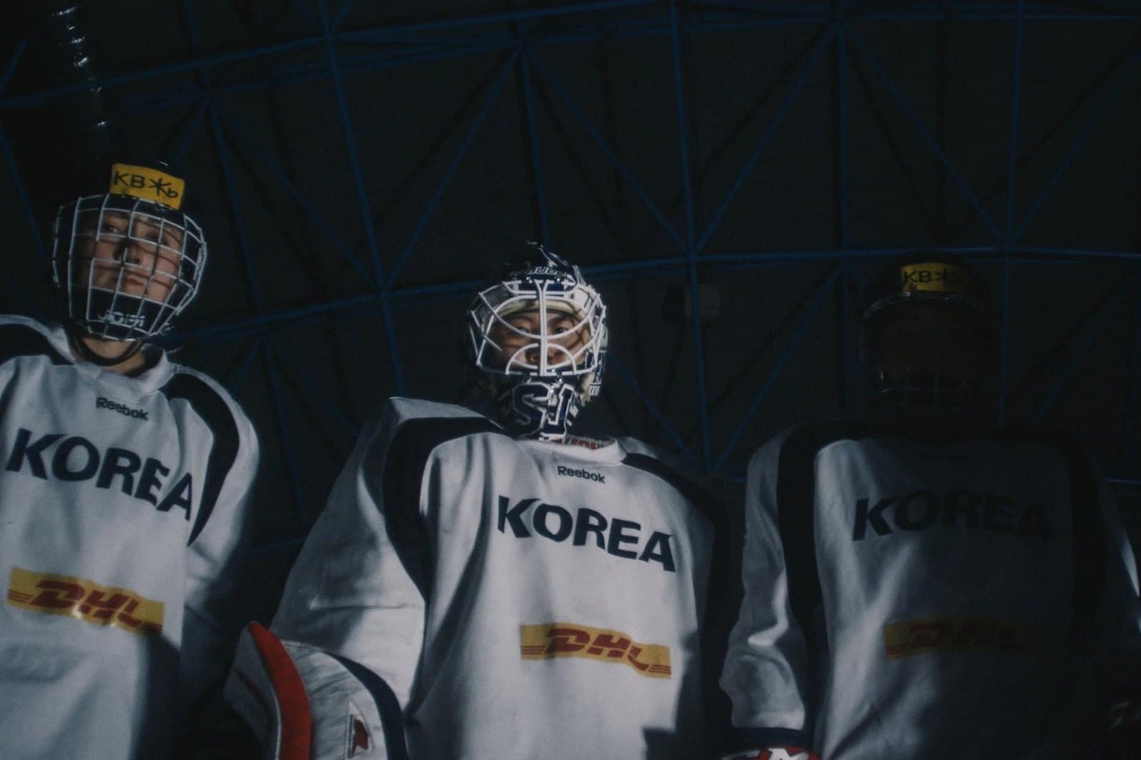 Korean hockey players in their kit, waiting to go on.