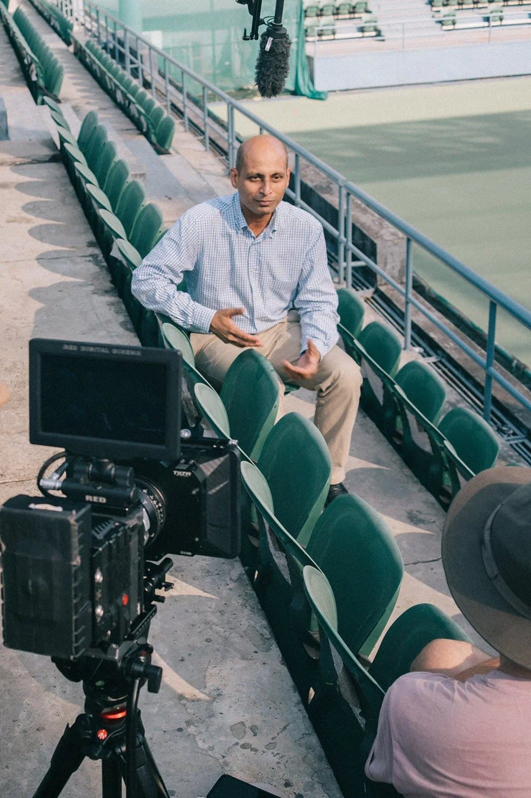 The crew filming an interview in the stands of a rink.
