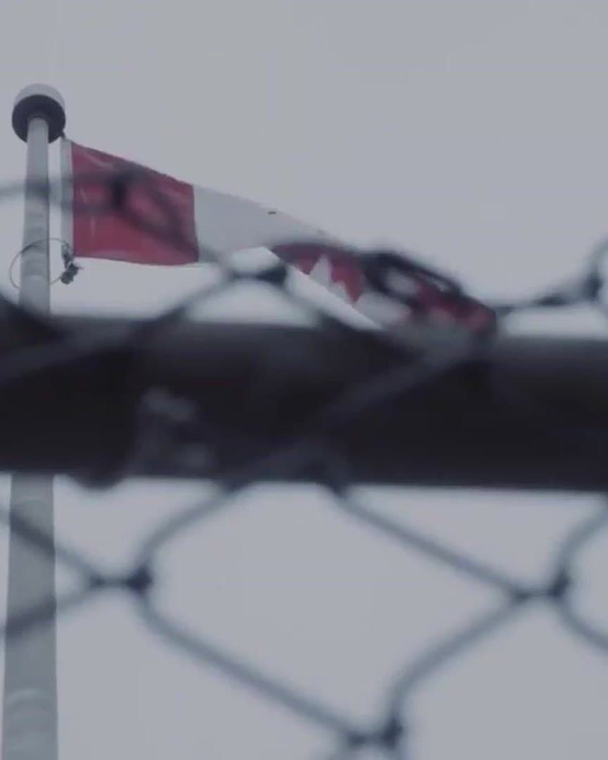 A flag tied to the fence of a rink.