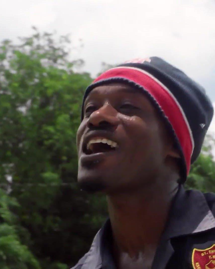A man in a striped beanie laughing, in Jamaica.