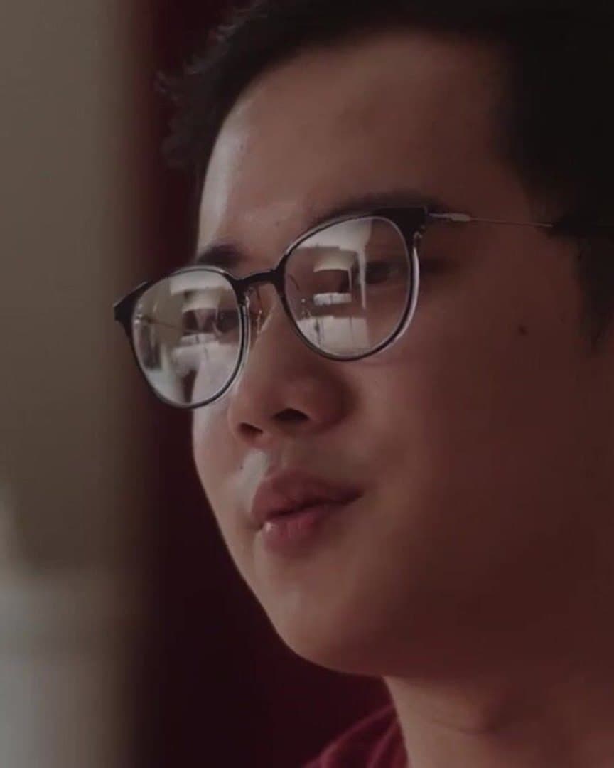 A man in glasses, listening.