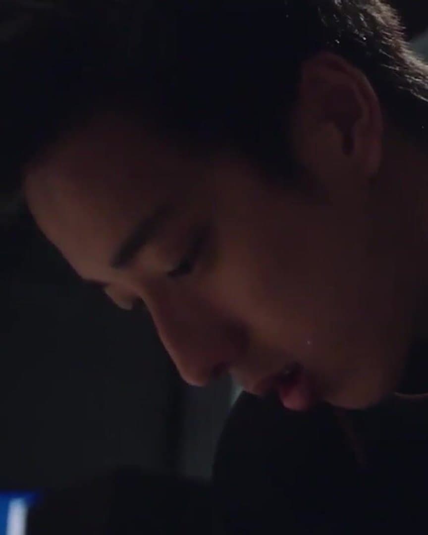 Julian Yee, head bowed, in the dark.