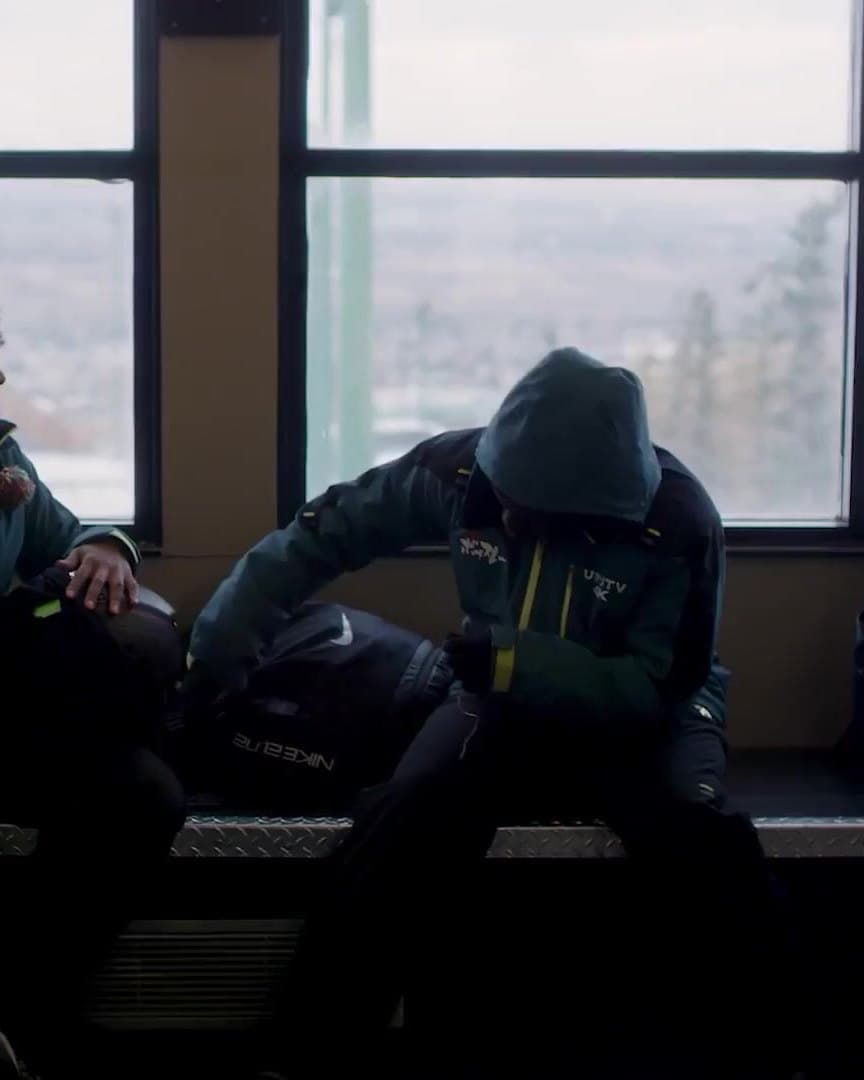 The Jamaican team waiting on a bench by a window.