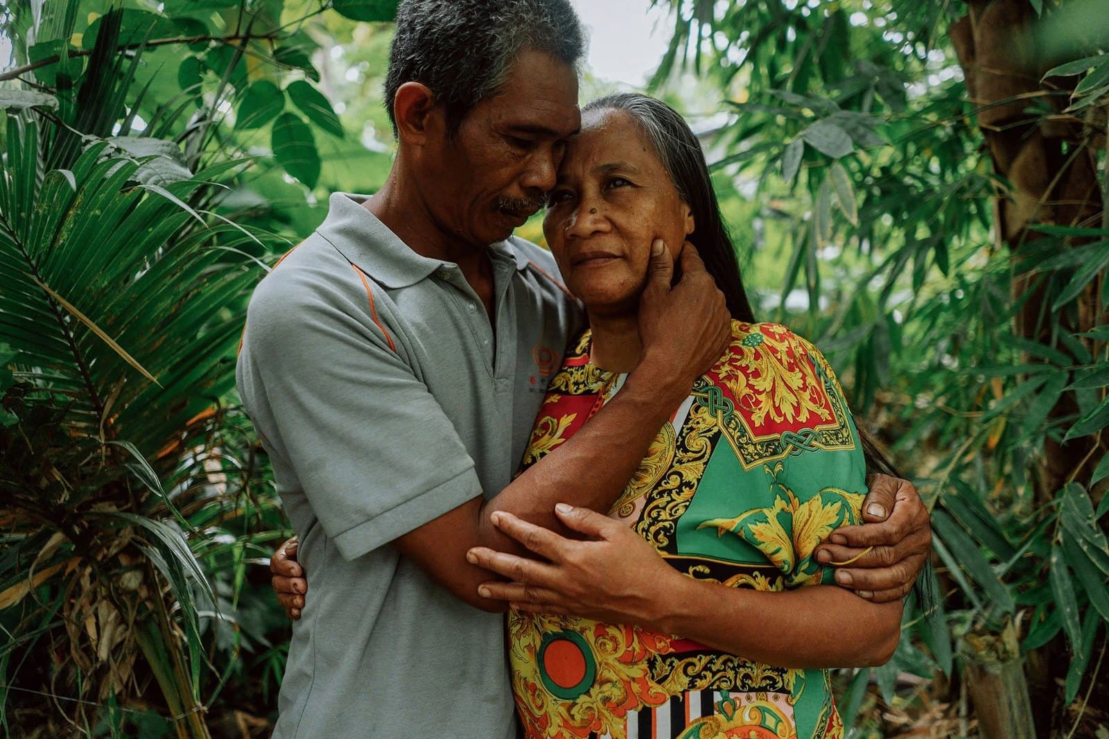 Virgilio holding Joanaly close among the trees.
