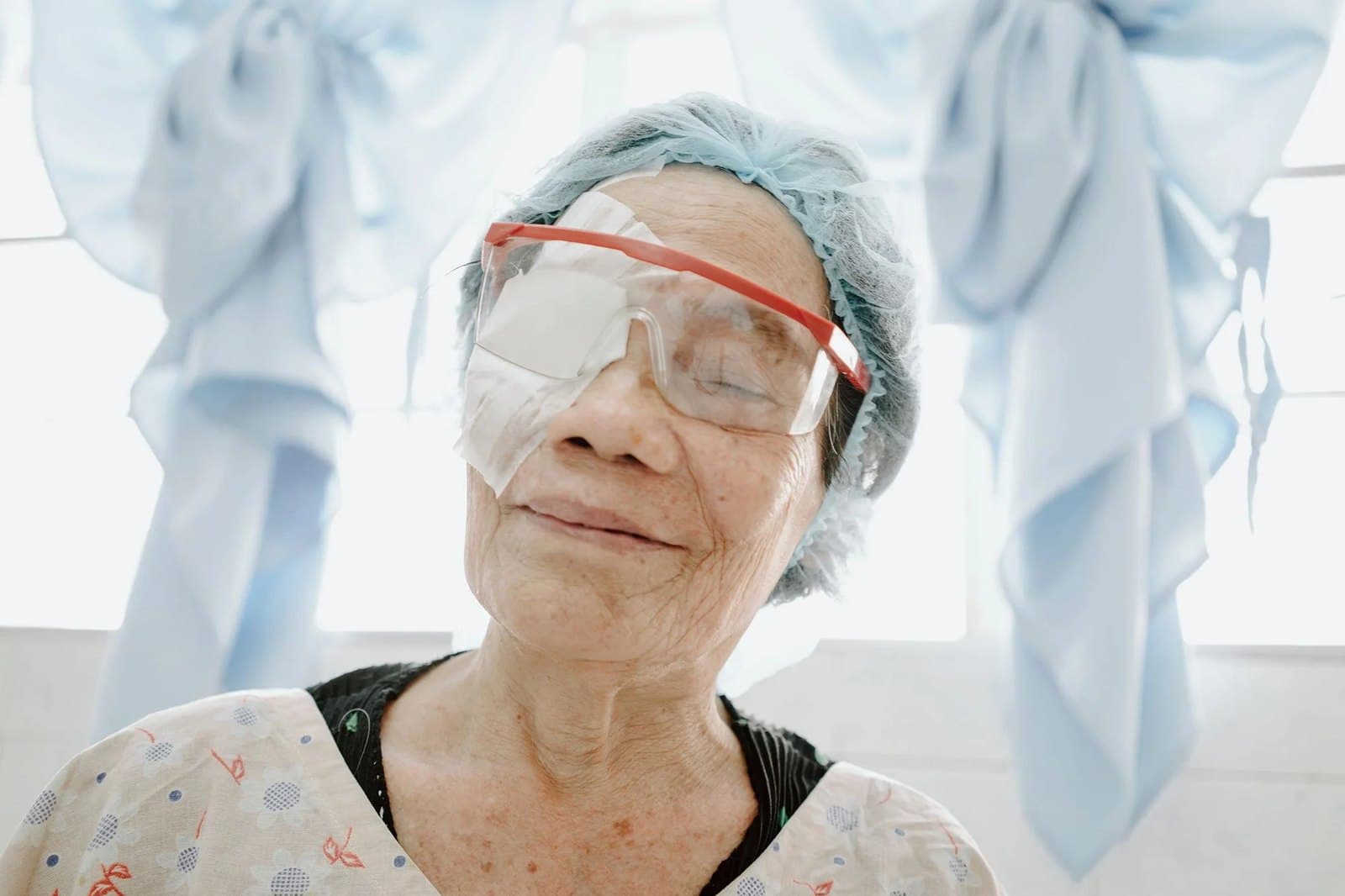 A patient in protective glasses after surgery, smiling.