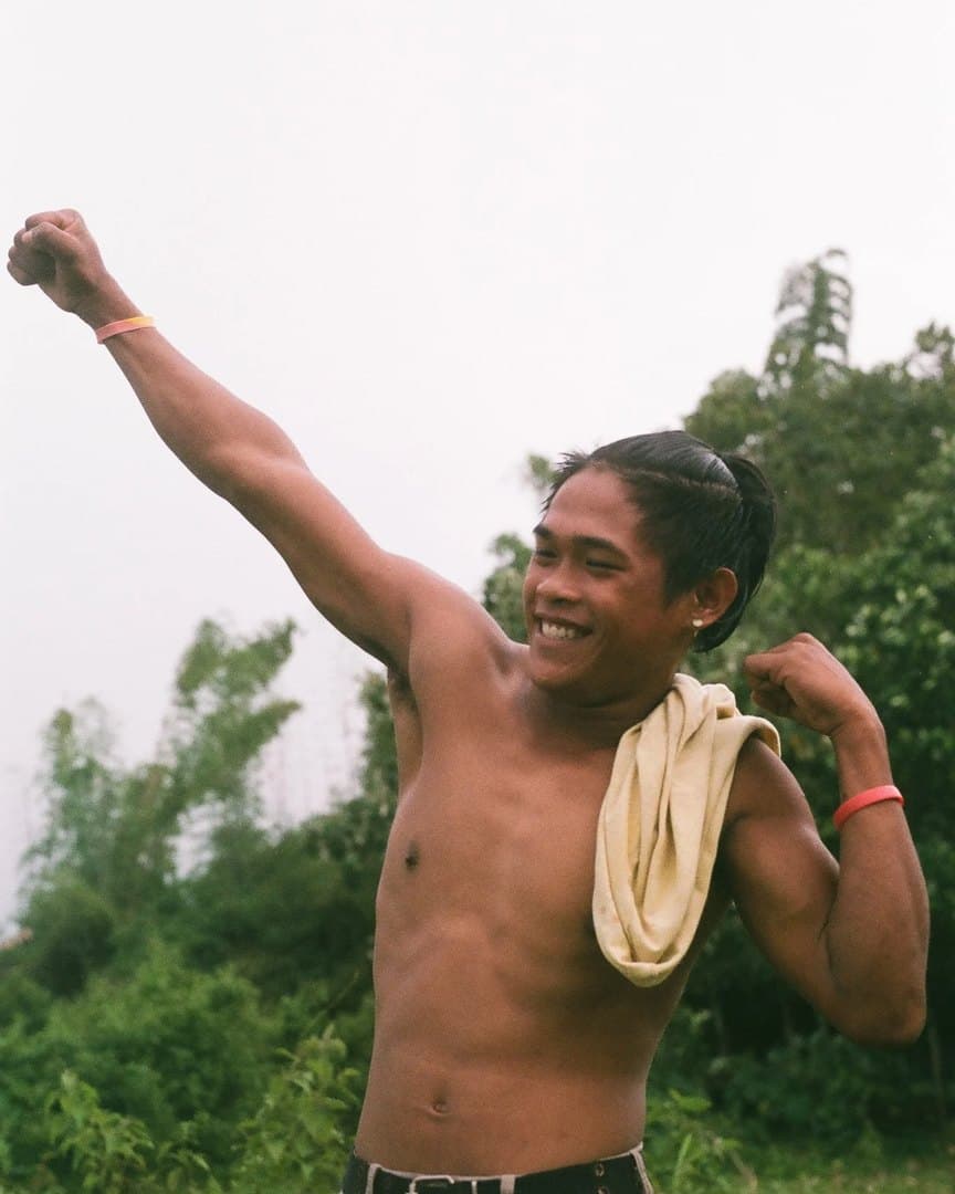 A young man laughing, a towel over his shoulder, on 35mm.
