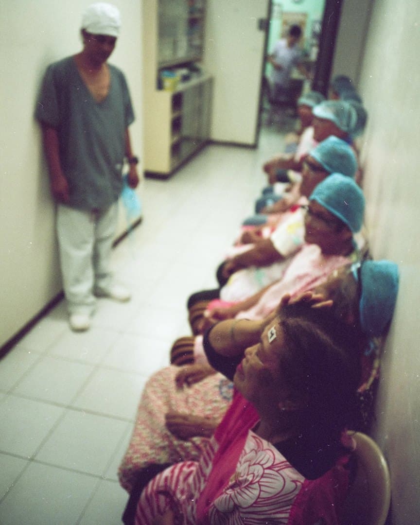 Patients in surgical caps waiting in the hospital corridor, on film.