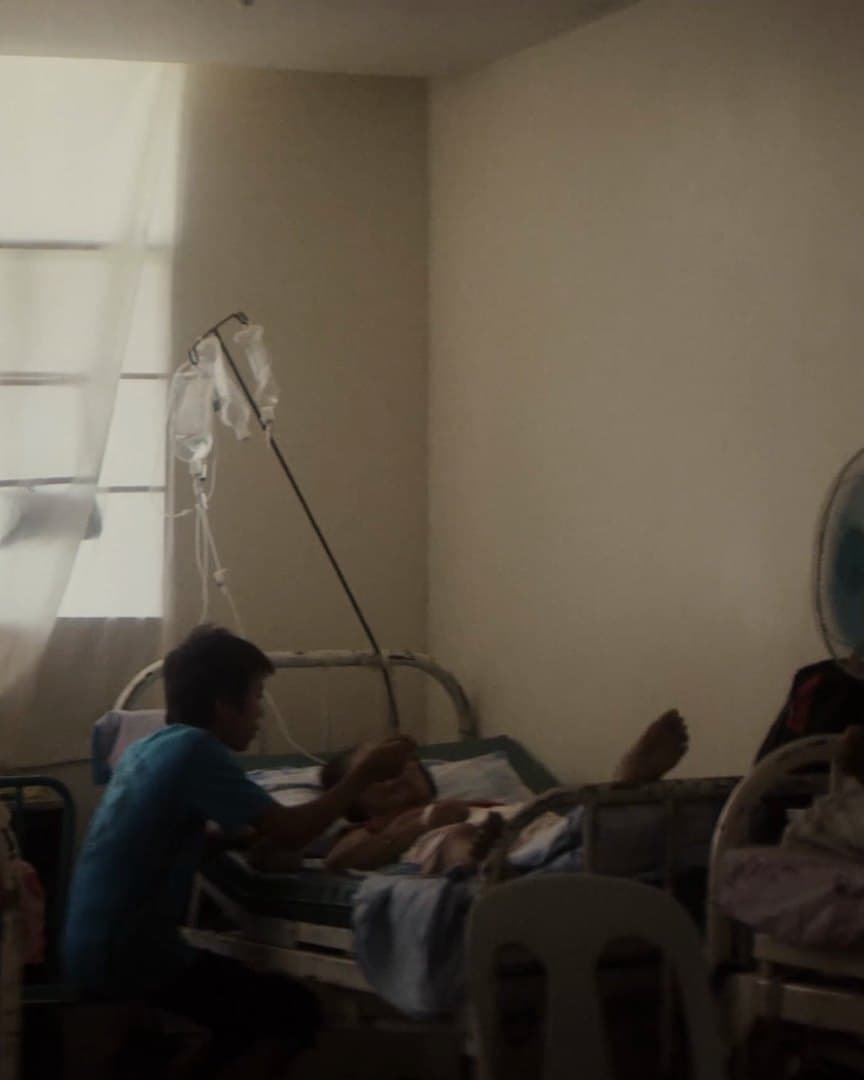 A ward seen through a doorway, a crucifix on the wall.