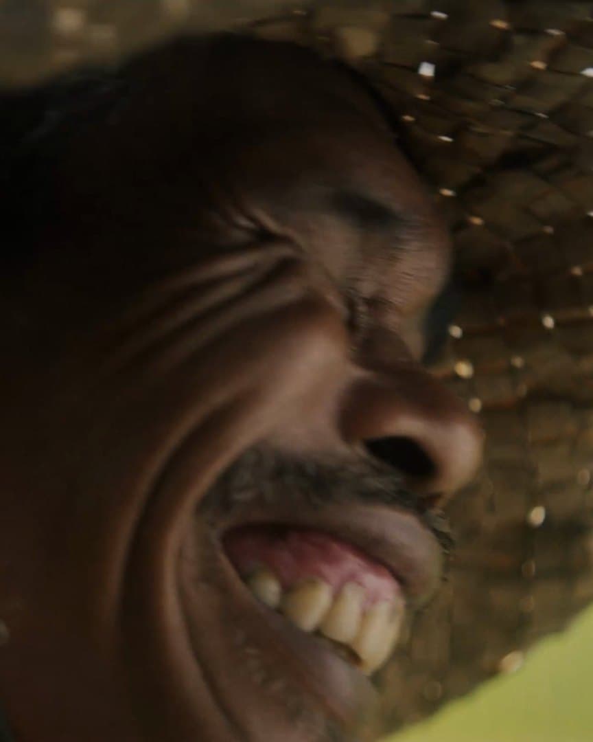 A farmer laughing under his straw hat.