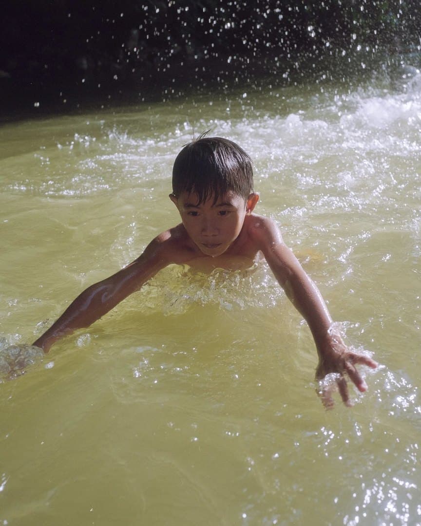 A boy swimming in the river, on film.