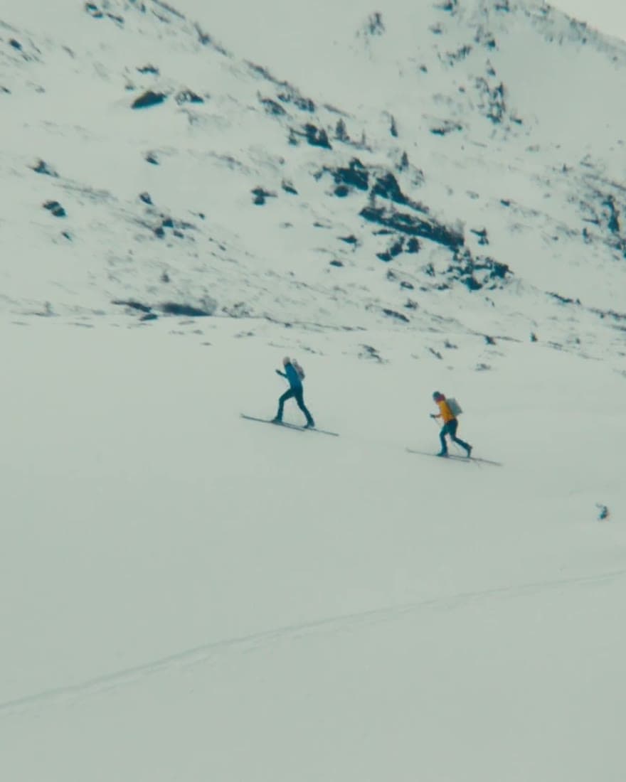 Two ski tourers crossing a snowfield in winter training.