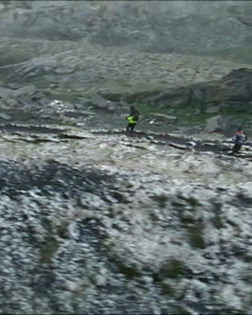 A runner alone on snow-dusted scree.