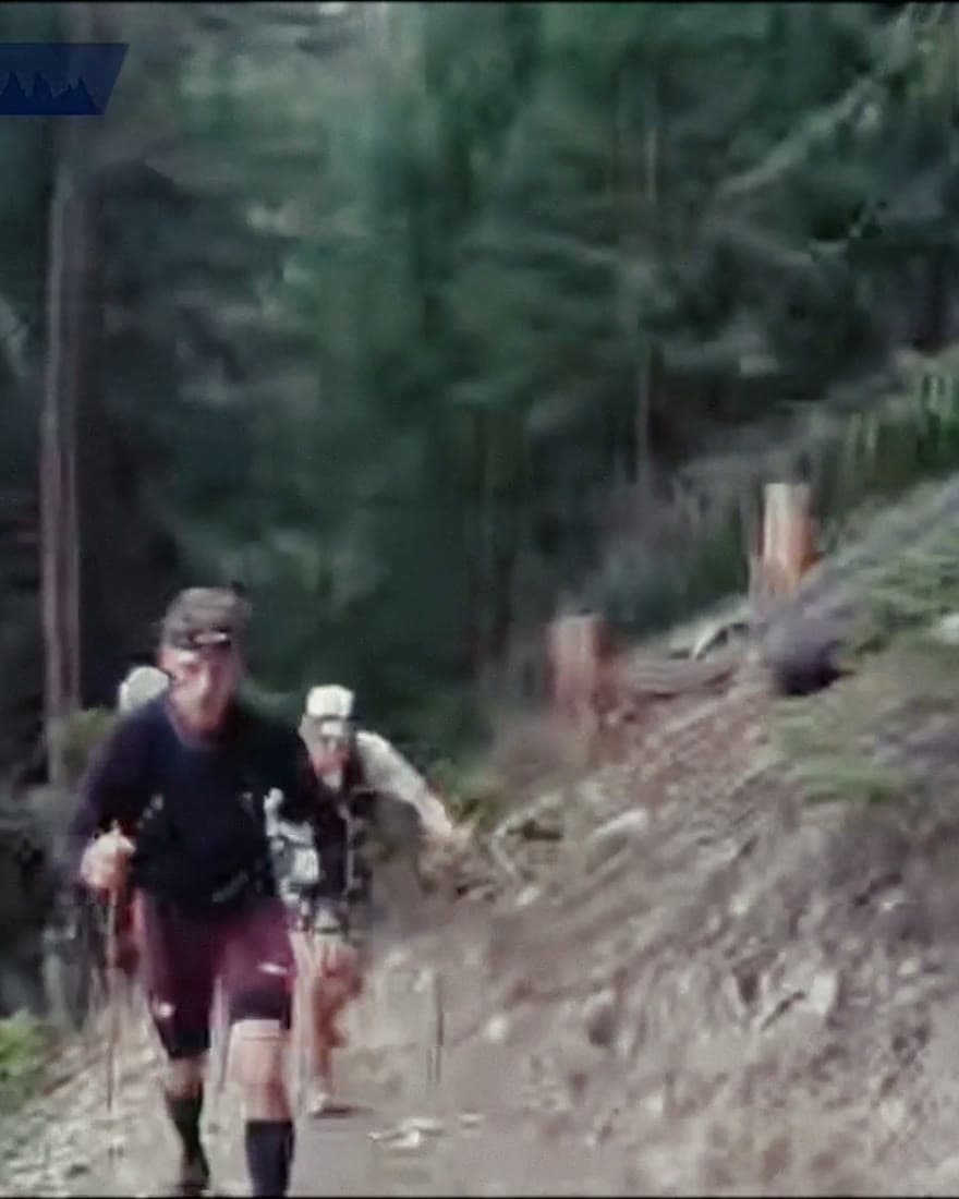 Runners climbing a dusty trail in close file.