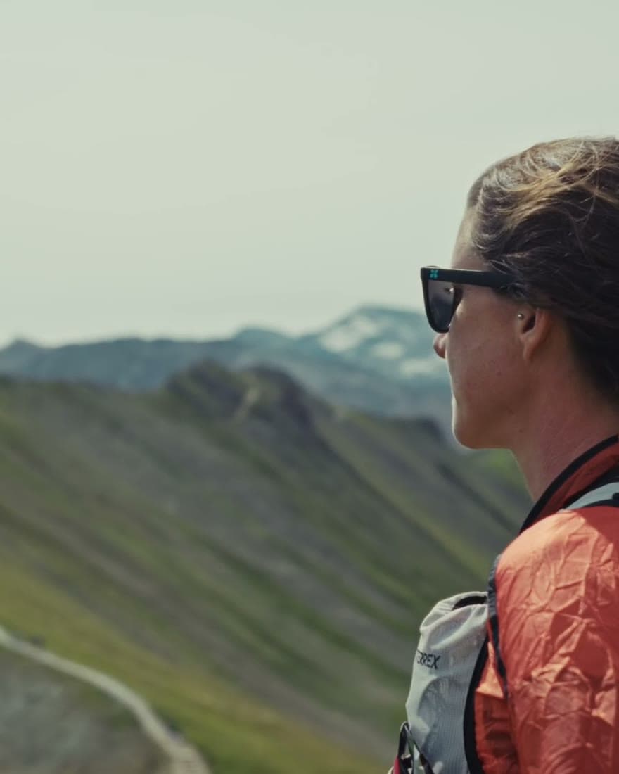 A runner looking out across a high ridge line.