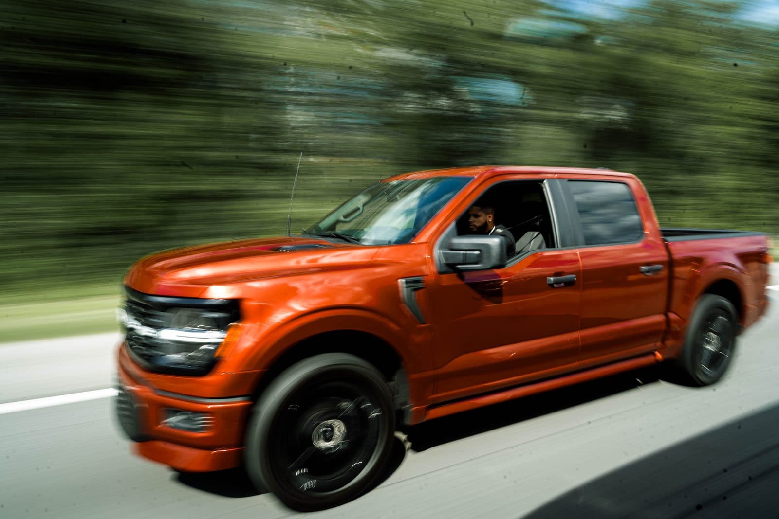 An F-150 at speed, the road blurring behind it.