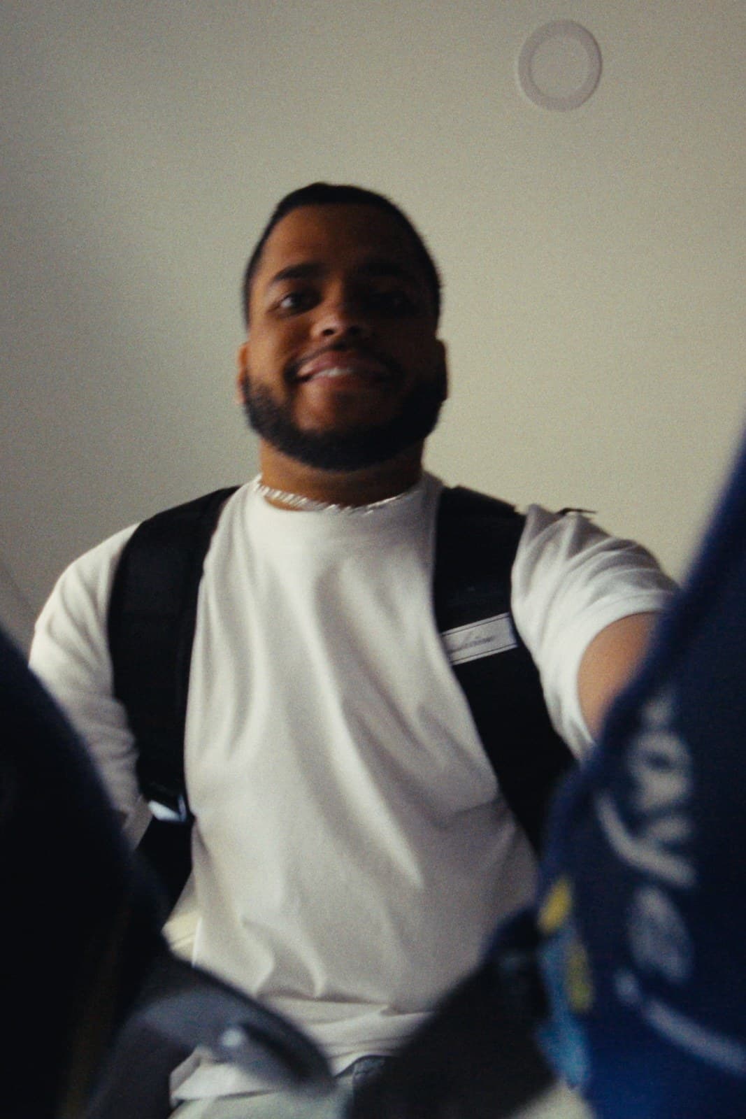One of the twins arriving home in Miami, backpack on.
