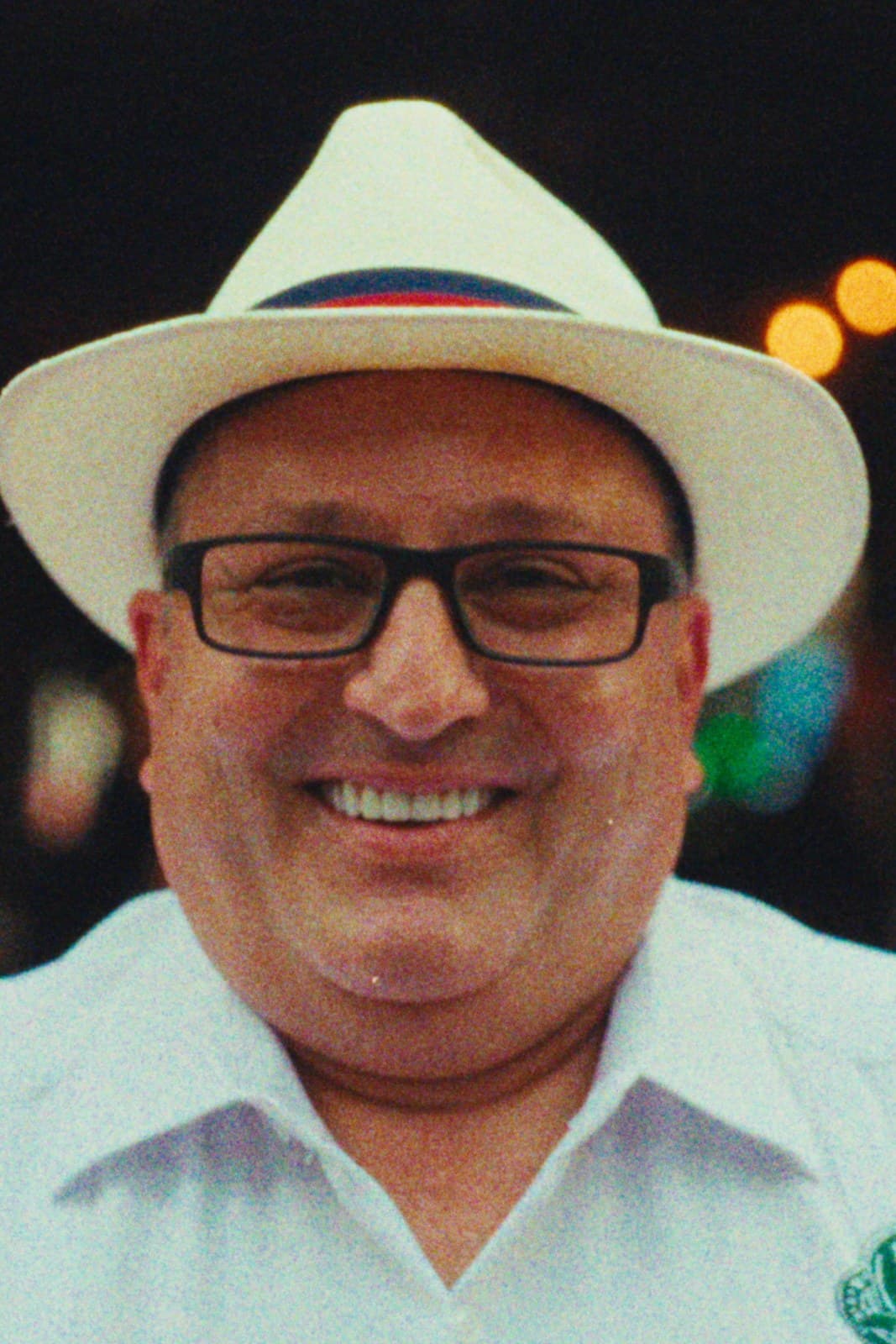 A man in a Panama hat, smiling, Miami.