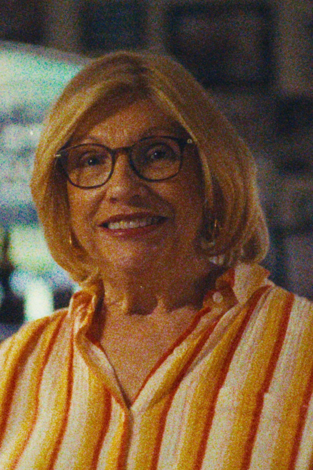 A woman in a striped shirt, smiling, Miami.
