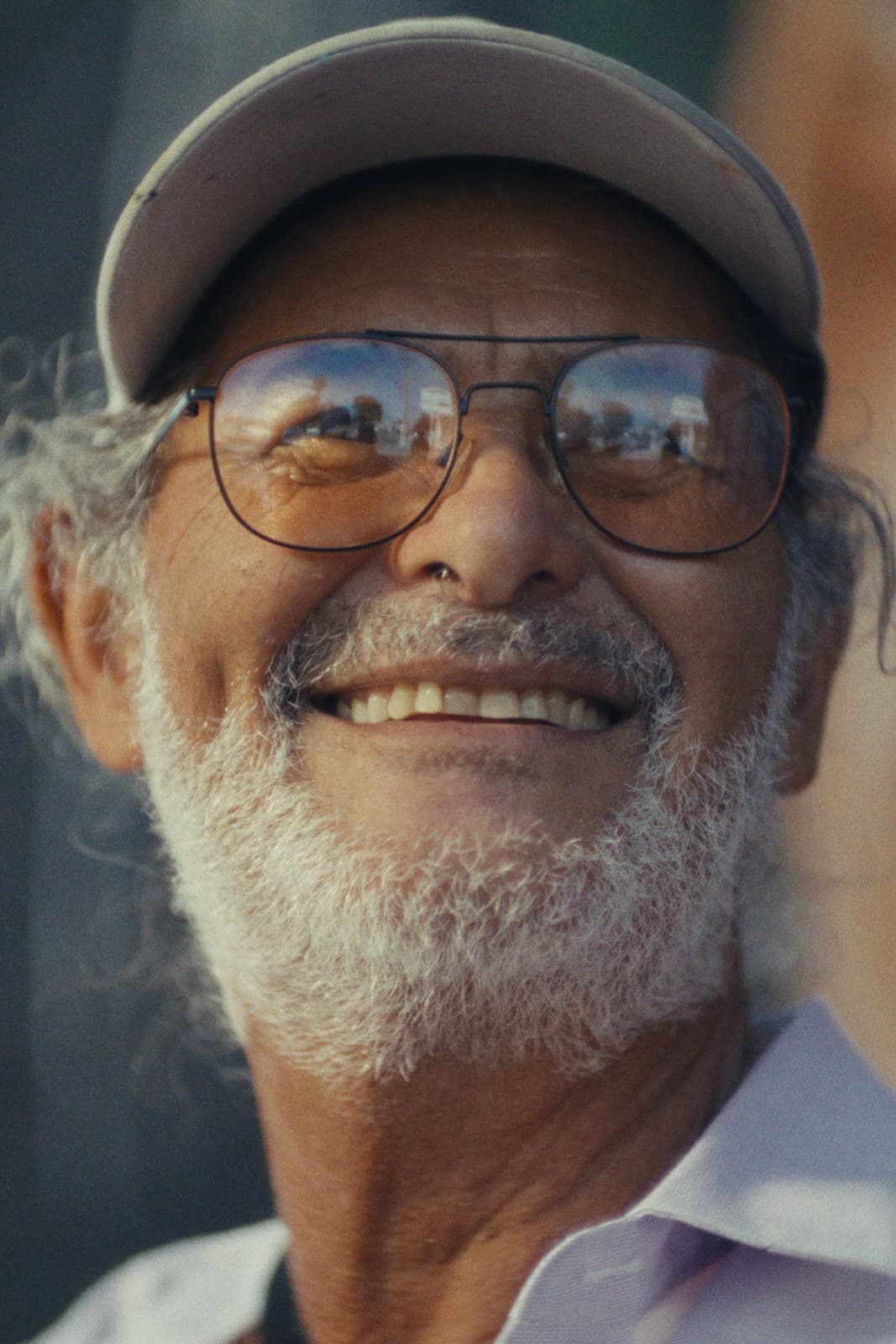 An elder muralist smiling in front of his mural, Pacoima.