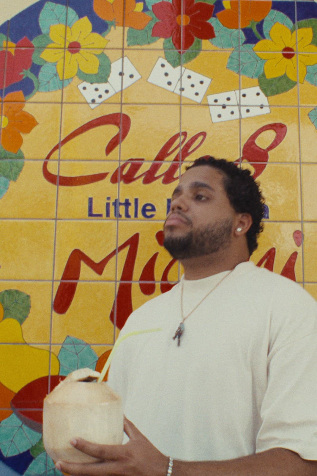 One of the twins with a coconut in front of the Calle Ocho tile mural, Little Havana.