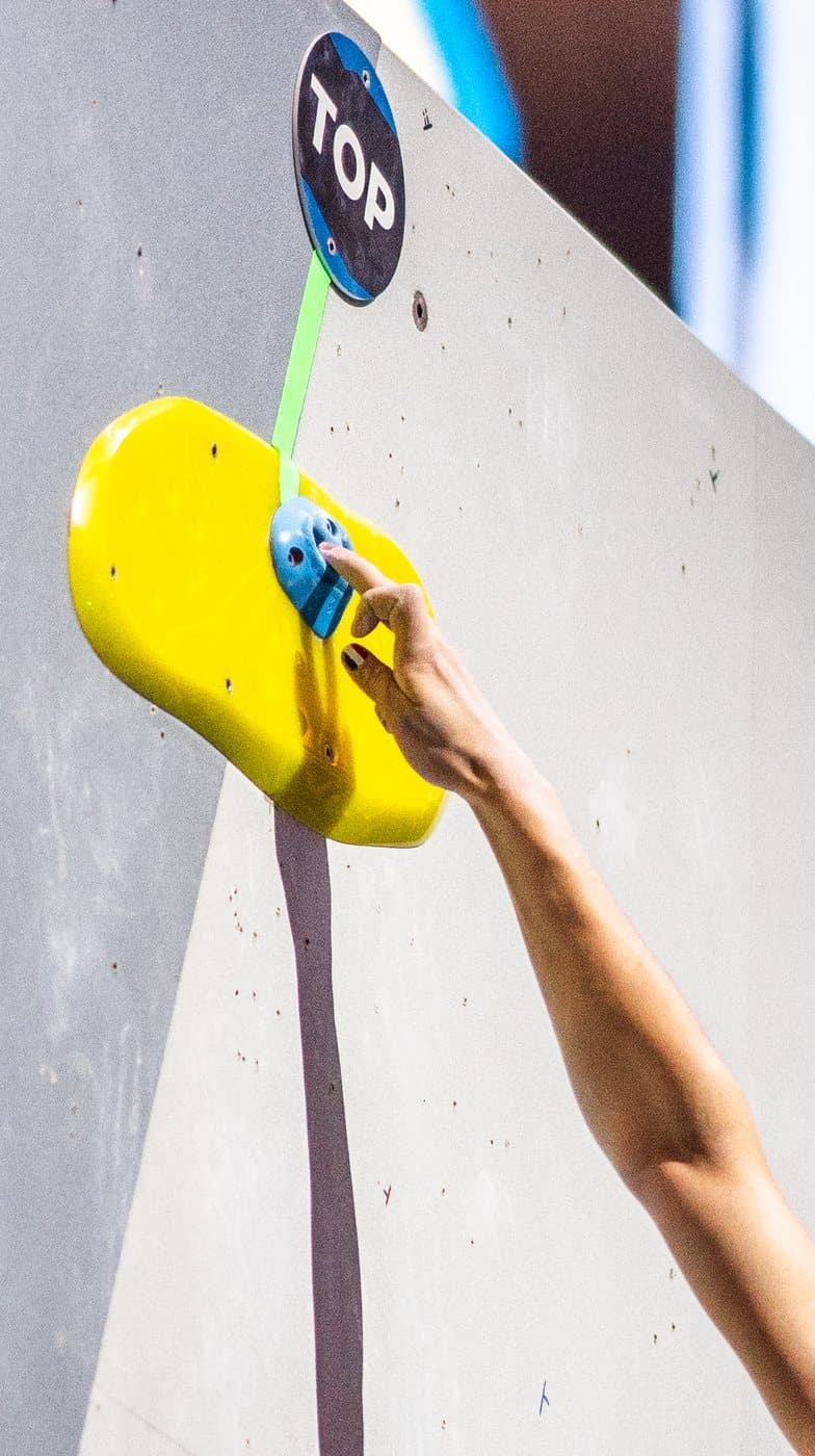 A chalked hand on a yellow hold.