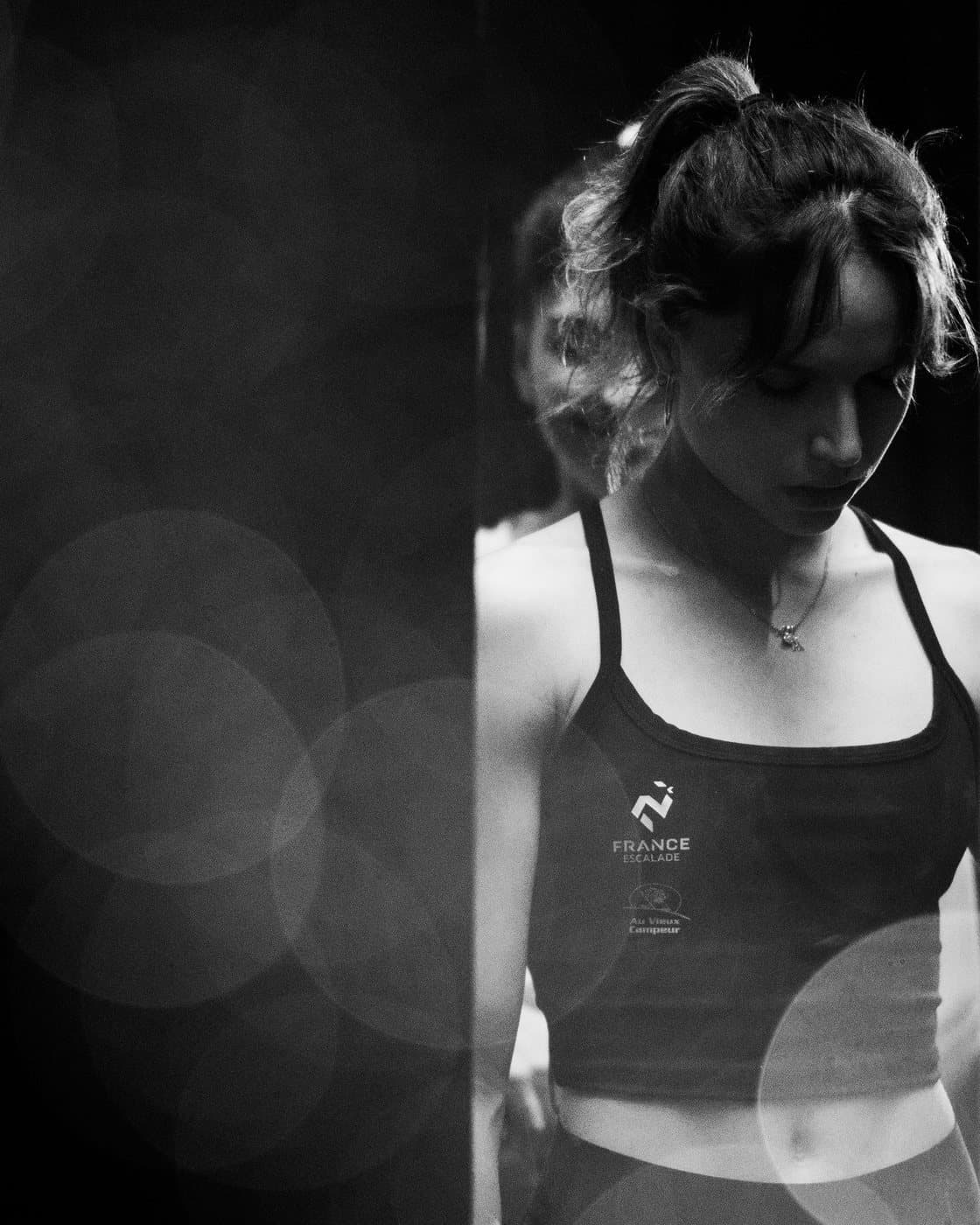A climber in black and white, eyes lowered.