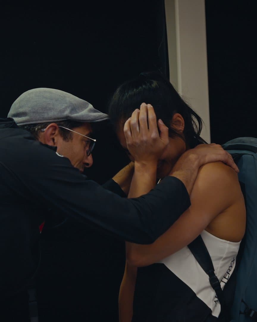 A coach holding an athlete after her round.