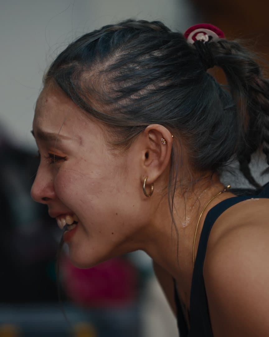 A climber crying, head bowed.