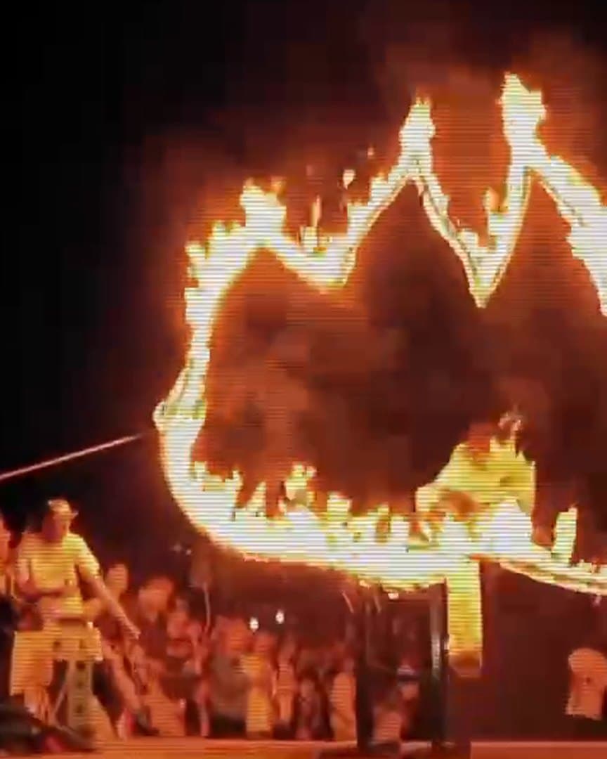 A ring of fire and a crowd at night, from the archive.