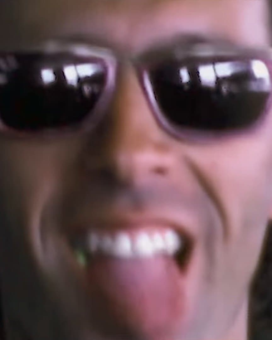 A skater grinning in sunglasses.