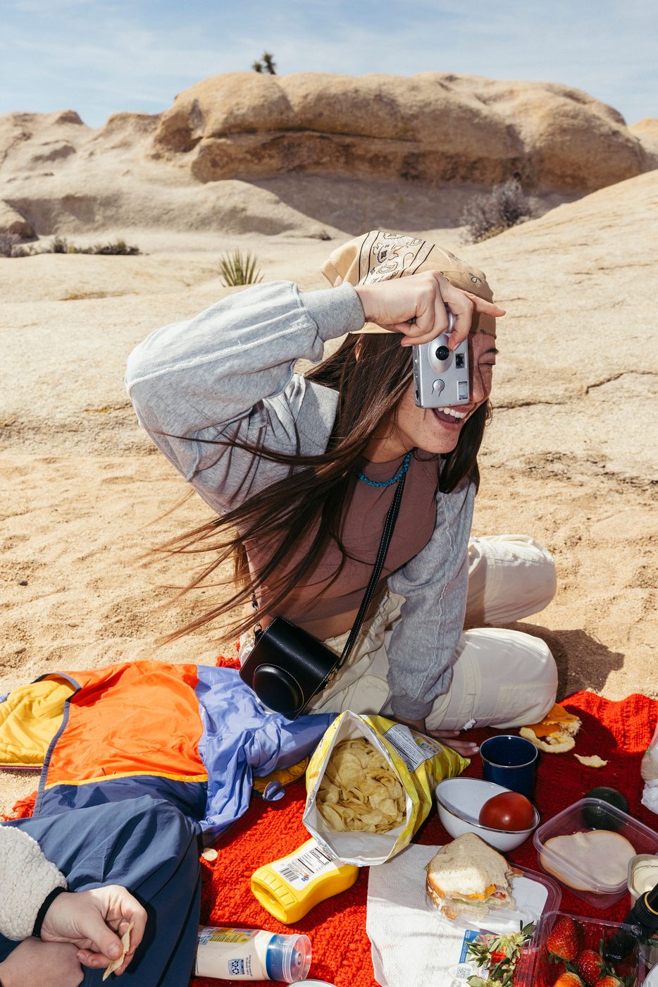 Talent shooting a disposable camera in the desert
