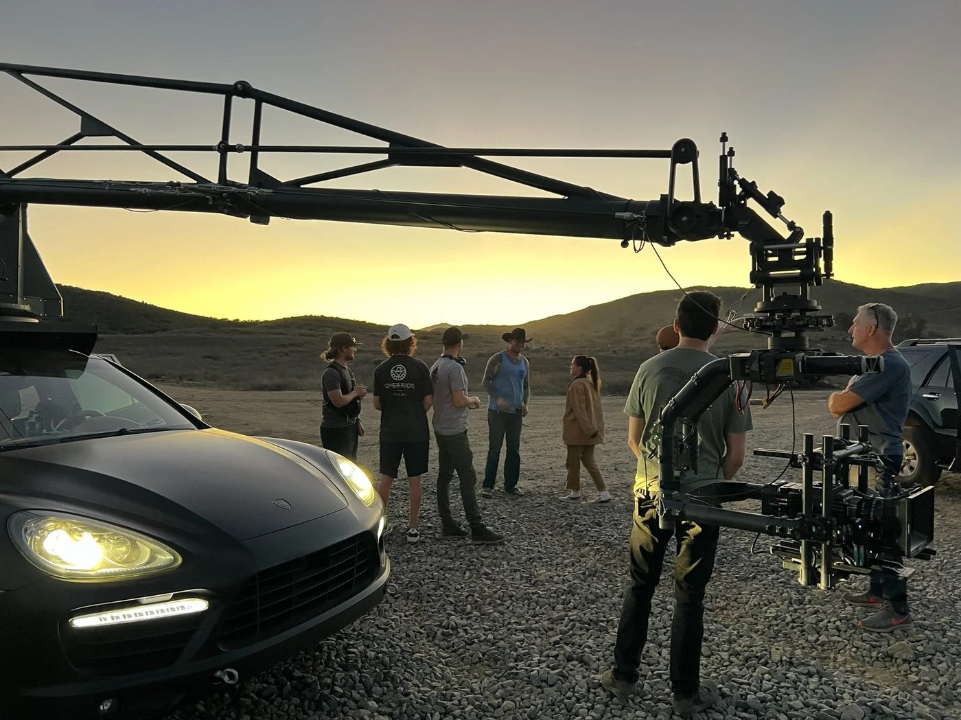 Camera crane car rigged at dusk with the crew around it